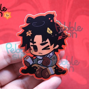 May include: A sticker featuring a cartoon character with black hair adorned with autumn leaves. The character is wearing a scarf and holding a cup. The sticker has a red outline and the words "Pebble Sun" are visible.