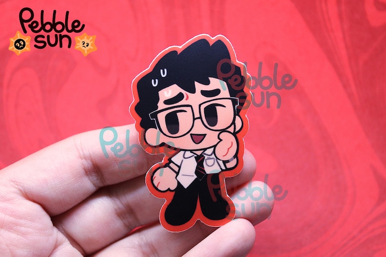 May include: A cartoon sticker featuring a character with black hair, glasses, and a white shirt with a tie. The sticker has a red border and the text "Pebble Sun" in the upper left corner. The character is giving a thumbs up.