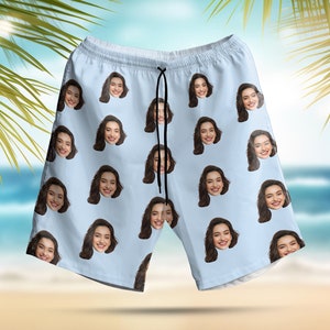 May include: Light blue swimming trunks with a repeating pattern of a woman's face.