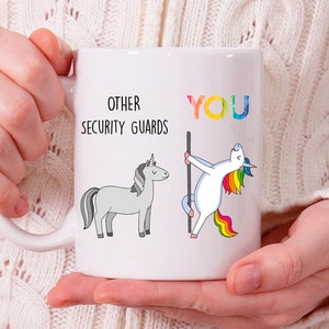 May include: White ceramic mug with a black and white unicorn illustration on the left side and a rainbow unicorn illustration on the right side. The text "Other Security Guards" is above the black and white unicorn and the text "You" is above the rainbow unicorn.