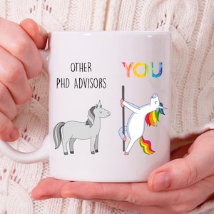 May include: White ceramic mug with a humorous illustration of two unicorns. The text on the mug reads "Other PHD Advisors" and "You". The unicorn representing "You" is depicted in a playful, suggestive pose.