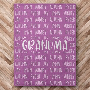 May include: A pink wooden sign with the word "GRANDMA" in white lettering. The sign is surrounded by a repeating pattern of the names Jay, Lynn, Aubrey, Autumn, and Ryder.