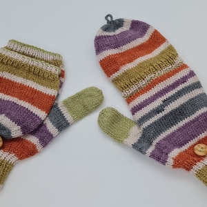 Könnte beinhalten: Ein Paar gestreifte Strickhandschuhe in Grün, Orange, Lila und Grau. Jeder Handschuh hat einen Holzknopf.