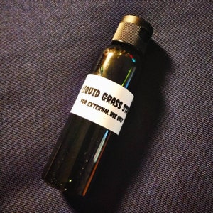May include: A small black bottle with a white label that reads "Liquid Grass Stain" and "For External Use Only".