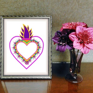 May include: A framed print of a colorful heart with a flame on top. The heart is surrounded by a pink, green, and yellow beaded border with small pink roses. The background is white.