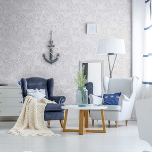 May include: A living room interior with two armchairs, a coffee table, a vase with greenery, and a decorative anchor hanging on the wall. The wall is covered in a white and gray patterned wallpaper.