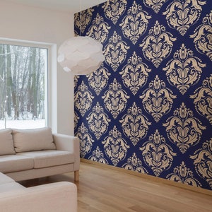 May include: A living room with a large window, a white lamp, and a beige couch. The wall is covered in blue and gold damask wallpaper.
