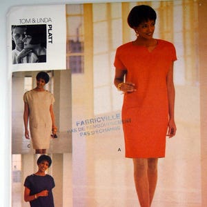 May include: A Vogue Attitudes sewing pattern envelope, number 1167, for a short-sleeved dress or top. The cover displays three variations: a bright orange dress, a beige dress, and a dark blue top with a white skirt, all featuring a notched neckline.