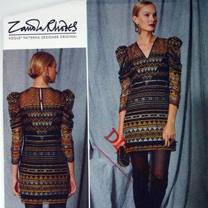Puede incluir: Patrón de costura Vogue, diseñador original de Zandra Rhodes. La imagen muestra un patrón de vestido con un diseño geométrico en marrón, negro y dorado. El patrón incluye tallas (42-50) y está impreso en EE. UU. El vestido tiene mangas largas y cuello en V.