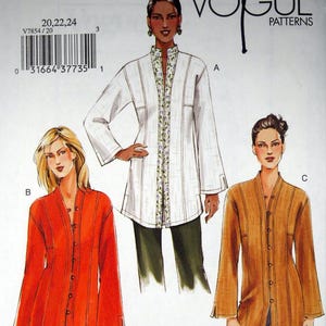 May include: Vogue Patterns sewing pattern V7854. The pattern features three long-sleeve tunic designs in white, orange, and tan. The pattern includes sizes 20, 22, and 24. The Vogue Patterns logo is at the top.