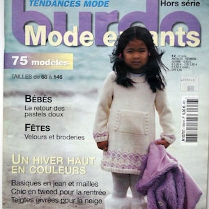 May include: A magazine cover featuring a young girl wearing a white and purple knitted dress and white boots. The magazine is titled "Mode Enfants" and features the text "75 modeles" and "Tailles de 68 a 146".