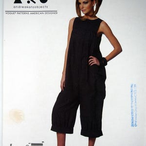 May include: A black sleeveless jumpsuit pattern by andrea katzobjects for Vogue Patterns. The pattern features a wide-leg design with a gathered waist and cropped length. The model is wearing the jumpsuit with black high-heeled sandals. The pattern size is BB (8-10-12-14).