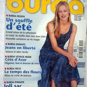 May include: A magazine cover with the title "Burda" in yellow, featuring a woman in a blue patterned dress. The cover includes French text such as "Tendances Mode" and "Un souffle d'été". The magazine is dated 5/99.