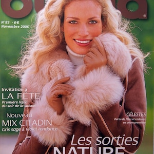 Può includere: Una copertina di rivista con una donna che indossa un cappotto di pelliccia sintetica marrone con un colletto di pelliccia bianca. La rivista è intitolata "Les sorties NATURE" e il testo "Tout ce qui réchauffe en hiver" è stampato sotto il titolo. La copertina della rivista presenta anche il testo "Invitation à LA FÊTE" e "Nouveau MIX CITADIN Gris sage & violet tendance".