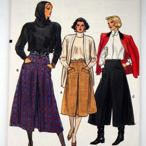 May include: Vogue Patterns sewing pattern featuring three women's fashion designs. The designs include a black turtleneck with a plaid skirt, a white cardigan with a tan skirt, and a red blazer with black culottes. The pattern size is (6-8-10).