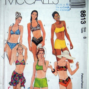 May include: Sewing pattern for a swimsuit with different styles and sizes. The pattern includes instructions for making a bikini top and bottom, a halter top and shorts, and a tank top and shorts. The pattern is for size 8 and includes separate pattern pieces for A/B cup and C/D cup.