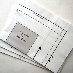 Może przedstawiać: Biały szablon papierowy z czarnym obrysem kwadratu z etykietą "test square 4x4in 10.1x10.1cm" i ikoną nożyczek.
