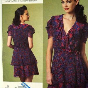 May include: Vogue Patterns American Designer Anna Sui dress pattern. The pattern features a floral print dress with a ruffled neckline and hem. The dress is shown in a purple and red floral print. The pattern number is V1178.