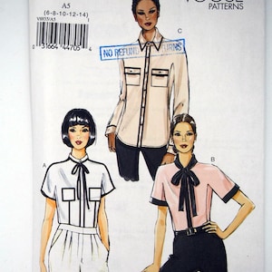 May include: Vogue Patterns V8855 sewing pattern envelope featuring illustrations of three shirt variations. View A is a white short-sleeve shirt with a tie neck and pockets. View B is a pink short-sleeve shirt with a dark tie. View C is a long-sleeve shirt.