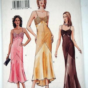 May include: Vogue Patterns sewing pattern V7850 featuring three elegant evening gowns. The pattern includes sizes 14, 16, and 18. The gowns are depicted in pink, gold, and brown, each with a unique design.