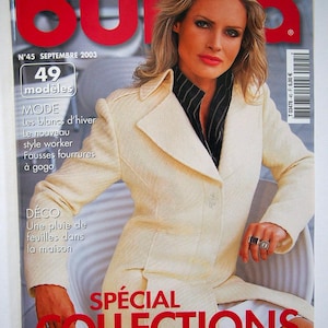 Puede incluir: Una portada de revista de moda con una mujer con un abrigo color crema. El título de la revista es "BURDA" en letras rojas grandes, con "TENDANCES MODE" encima. La portada también incluye el texto "SPÉCIAL COLLECTIONS".