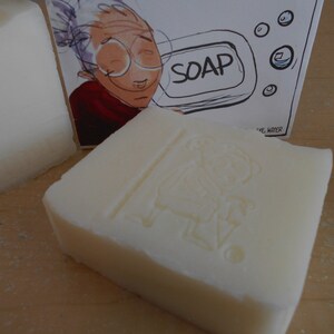 Pu&ograve; includere: Due saponette bianche con un'immagine di cartone animato di una donna con gli occhiali e la parola "SOAP" stampata sulla confezione.