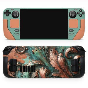 Może przedstawiać: Skórka w kolorze turkusowym i miedzianym do przenośnego urządzenia do gier. Skórka ma ozdobny wzór z misternymi detalami. Urządzenie ma przyciski oznaczone literami "X", "Y", "A" i "B".