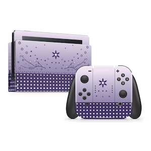 Puede incluir: Una piel para consola y mando de Nintendo Switch de color morado y blanco con un patrón de lunares y un diseño floral. El diseño presenta una pequeña flor en el centro del mando y una flor más grande en la consola.