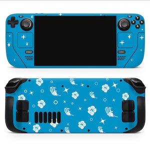 Puede incluir: Una funda azul para consola de juegos portátil con pantalla negra y controles. La funda está decorada con estrellas blancas y un estampado floral de flores y mariposas blancas. La consola tiene detalles y botones negros.