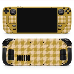May include: A handheld gaming console with a yellow and beige plaid pattern. The console features a black screen, buttons, and control sticks. The back of the console also has the plaid pattern and black buttons.
