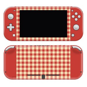 Könnte beinhalten: Rote Handheld-Spielkonsole mit einem cremefarbenen und roten Vichy-Muster auf der Vorder- und Rückseite. Die Konsole hat einen schwarzen Bildschirm und verschiedene Tasten und Bedienelemente. Das Design verleiht der Konsole eine Retro-Ästhetik.
