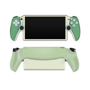 Puede incluir: Una consola de juegos portátil verde y blanca con mandos desmontables. La consola tiene una pantalla negra y un borde verde claro alrededor de los bordes.