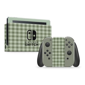 Könnte beinhalten: Eine Nintendo Switch-Konsole und Controller mit einem grün-weißen Vichy-Muster. Auf der Konsole befindet sich das schwarze Nintendo Switch-Logo. Die Controller sind grau und schwarz.