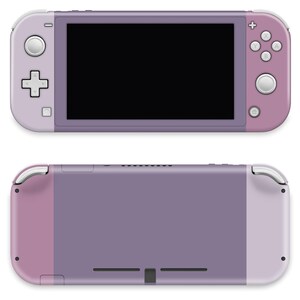 May include: A lavender and pink handheld game console, viewed from the front and back. The front features a black screen, control buttons, and a directional pad. The back has a solid lavender color with a kickstand and ports.