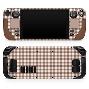 Może przedstawiać: Skórka na konsolę Steam Deck z brązowo-białym wzorem w kratkę vichy. Skórka pokrywa przód i tył urządzenia, z brązowymi akcentami na uchwytach i wokół przycisków. Steam Deck ma czarny ekran i przyciski.