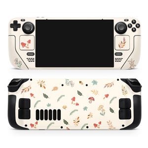 May include: A white and black handheld gaming console with a cream-colored skin featuring a pattern of mushrooms, leaves, and flowers. The console has a black screen and black buttons.