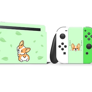 Może przedstawiać: Jasnozielona konsola Nintendo Switch i kontrolery z motywem corgi. Konsola ma ilustrację corgi i akcenty liści. Kontrolery są biało-zielone z grafiką corgi.