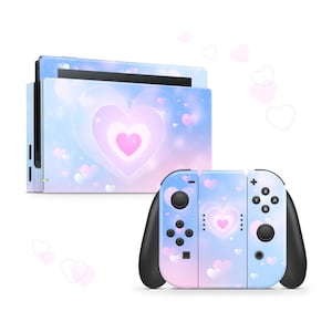 May include: A pink and blue Nintendo Switch console and controller skin with a heart pattern. The skin features a large heart in the center with smaller hearts scattered around it. The background is a soft, pastel blue with a hint of pink.