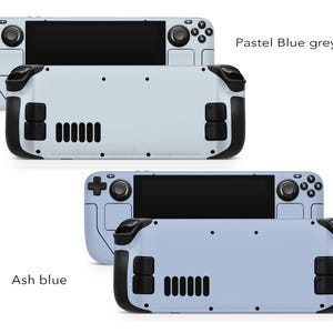 May include: Two handheld gaming devices with different colour schemes. The top device is a light blue grey colour with the text "Pastel Blue grey". The bottom device is a light blue colour with the text "Ash blue". Both devices have black buttons and a black screen.