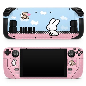 May include: Pink and blue Nintendo Switch console skin with a cute bunny and bear design. The skin features a polka dot pattern and a white bunny with a heart.