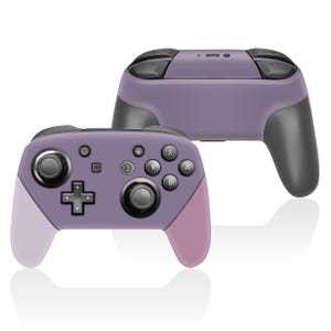 May include: Two purple and gray game controllers. The controllers have a variety of buttons, including a directional pad, face buttons, and shoulder buttons. The grips are a lighter shade of purple and pink.