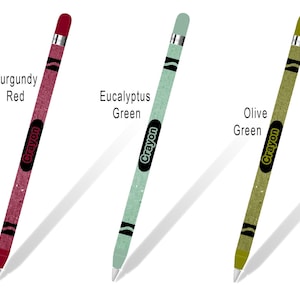 May include: Three Apple Pencil skins with a crayon design. The skins are in burgundy red, eucalyptus green, and olive green. Each skin has the word "Crayon" printed on it.