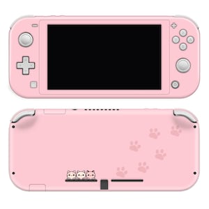 May include: Pink Nintendo Switch Lite console with a pink and white paw print design on the back. The console has a black screen and a white button on the left side. The console is in a closed position.