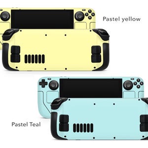 May include: Two handheld gaming consoles with different coloured faceplates. The top console has a pastel yellow faceplate and the bottom console has a pastel teal faceplate. Both consoles have black buttons and a black screen.