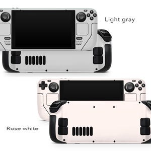 May include: Two handheld gaming devices, one in light grey and one in rose white. Both devices have a black screen, black buttons, and a black joystick. The text "Light grey" and "Rose white" is visible on the image.