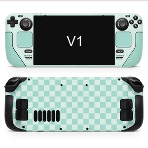 May include: A mint green handheld games console with black detailing. The front displays a black screen with the text "V1". The rear has a mint green and white chequered pattern.