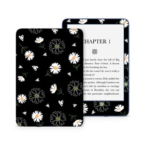 May include: A black and white floral pattern with white daisies and hearts on a black background. The pattern is on a Kindle e-reader cover. The Kindle e-reader is displaying the text "CHAPTER 1" and a short excerpt from a book.