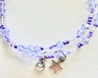 Conjunto de pulsera de cristal morado y cuentas pequeñas con dijes.
