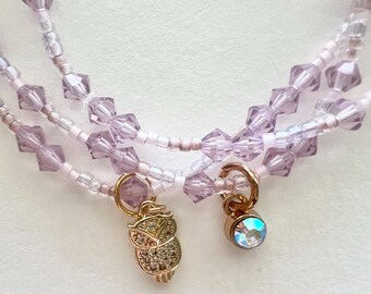 Conjunto de pulsera de cristal lila y cuentas pequeñas con dijes.