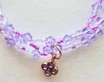 Conjunto de pulsera de cristal morado y cuentas pequeñas con dijes.